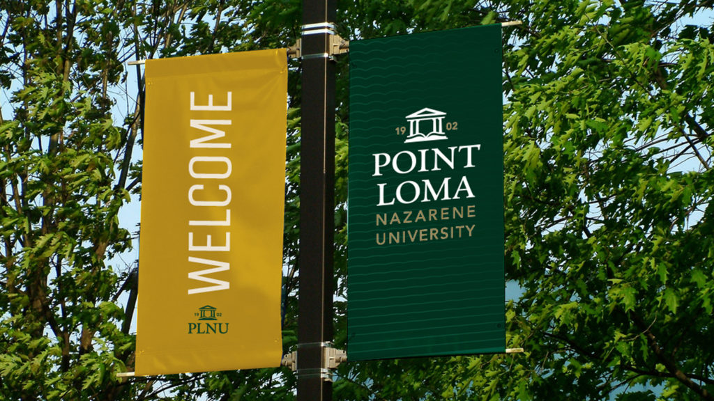 PLNU welcome flags in gold and green. 